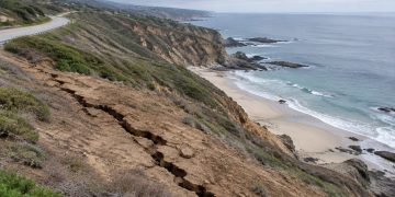 High view of a long crack in a dry coastal hillside below Pacific Coast Highway above Moro Beach near Laguna Beach in neutral daylight.