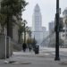 Long-lens view down an emptied Spring Street in downtown Los Angeles toward City Hall in afternoon daylight, with scattered litter on the sidewalk.