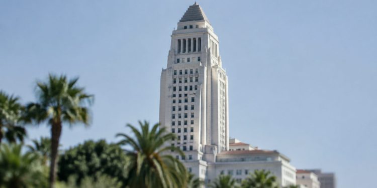 Los Angeles City Hall in neutral daylight, its tower sharp above softly blurred palm trees, illustrating the Los Angeles mayoral runoff.