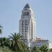 Los Angeles City Hall in neutral daylight, its tower sharp above softly blurred palm trees, illustrating the Los Angeles mayoral runoff.