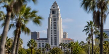 Los Angeles City Hall tower in daylight above softly blurred palm trees, illustrating the 2026 Los Angeles mayoral race.