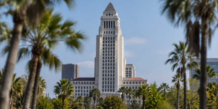 Los Angeles City Hall tower in daylight above softly blurred palm trees, illustrating the 2026 Los Angeles mayoral race.