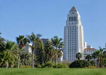 Los Angeles City Hall tower in neutral daylight above softly blurred palm trees, illustrating the 2026 Los Angeles mayoral race.
