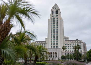 Los Angeles City Hall tower in neutral daylight above softly blurred palm trees, illustrating the 2026 Los Angeles mayoral race.