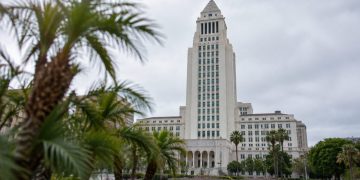 Los Angeles City Hall tower in neutral daylight above softly blurred palm trees, illustrating the 2026 Los Angeles mayoral race.