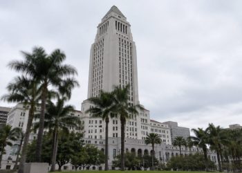 Los Angeles City Hall tower in neutral daylight above softly blurred palm trees, illustrating the 2026 Los Angeles mayoral race.