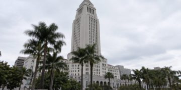 Los Angeles City Hall tower in neutral daylight above softly blurred palm trees, illustrating the 2026 Los Angeles mayoral race.