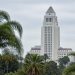 Los Angeles City Hall tower in neutral daylight above softly blurred palm trees, illustrating the Los Angeles mayoral runoff.
