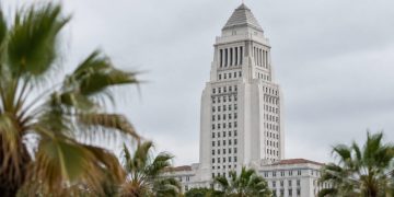Los Angeles City Hall tower sharp in neutral daylight with softly blurred palm trees in the foreground, illustrating the 2026 Los Angeles mayoral race.
