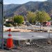 Rebuilding site in Altadena with a bare concrete foundation and temporary fencing in focus, foothills softly blurred behind, illustrating Eaton Fire recovery.