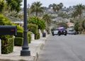 Residential street in Ladera Heights in daylight, with a mailbox and lamp post in the foreground and a patrol SUV blurred in the background.