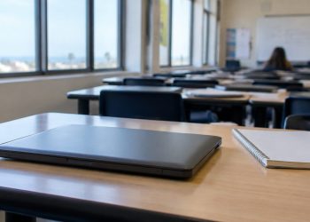 Rows of closed student laptops on desks in an empty Southern California classroom in afternoon daylight, illustrating the student data breach.