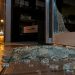Shattered glass pieces on the tile floor at the threshold of a restaurant's glass door at night in Arcadia, lit by a nearby street lamp.